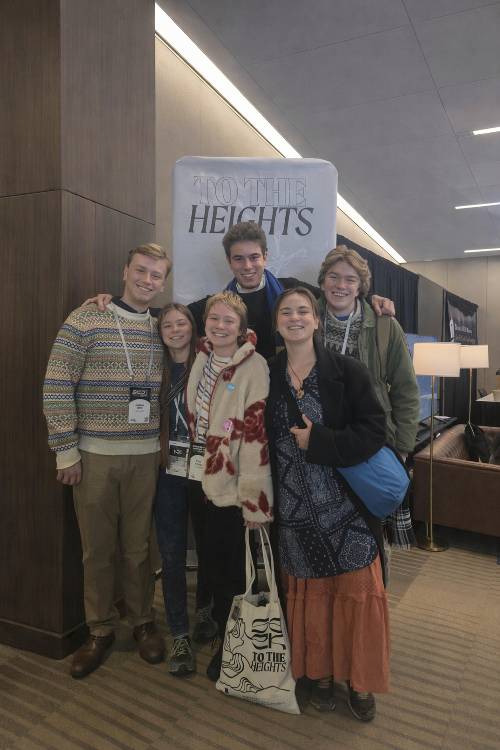 Six Students of Saint Augustine members together at the SEEK conference, in front of a To The Heights banner
