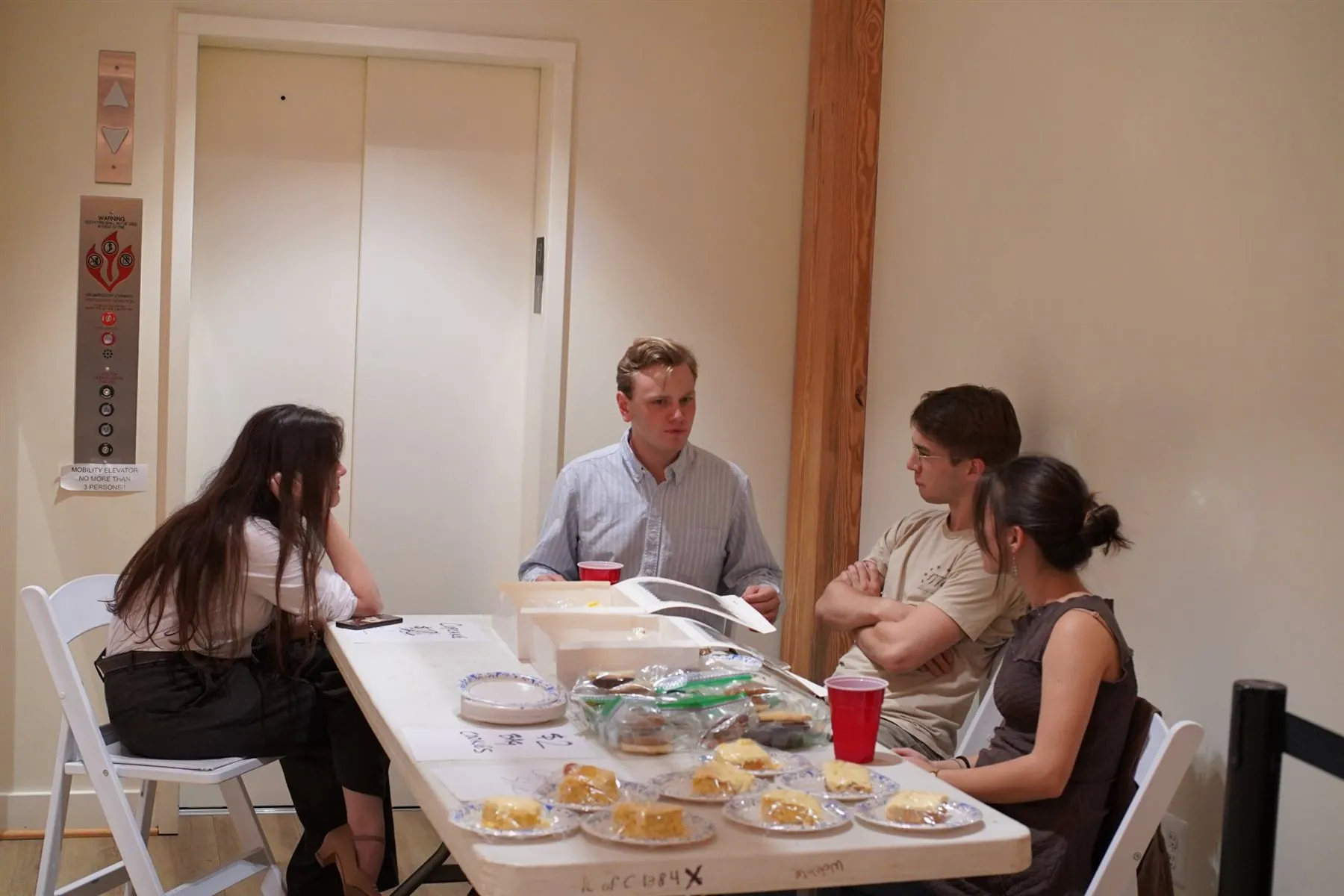 Students talking around a bake sale table
